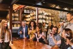 Group of people drinking among wine barrels